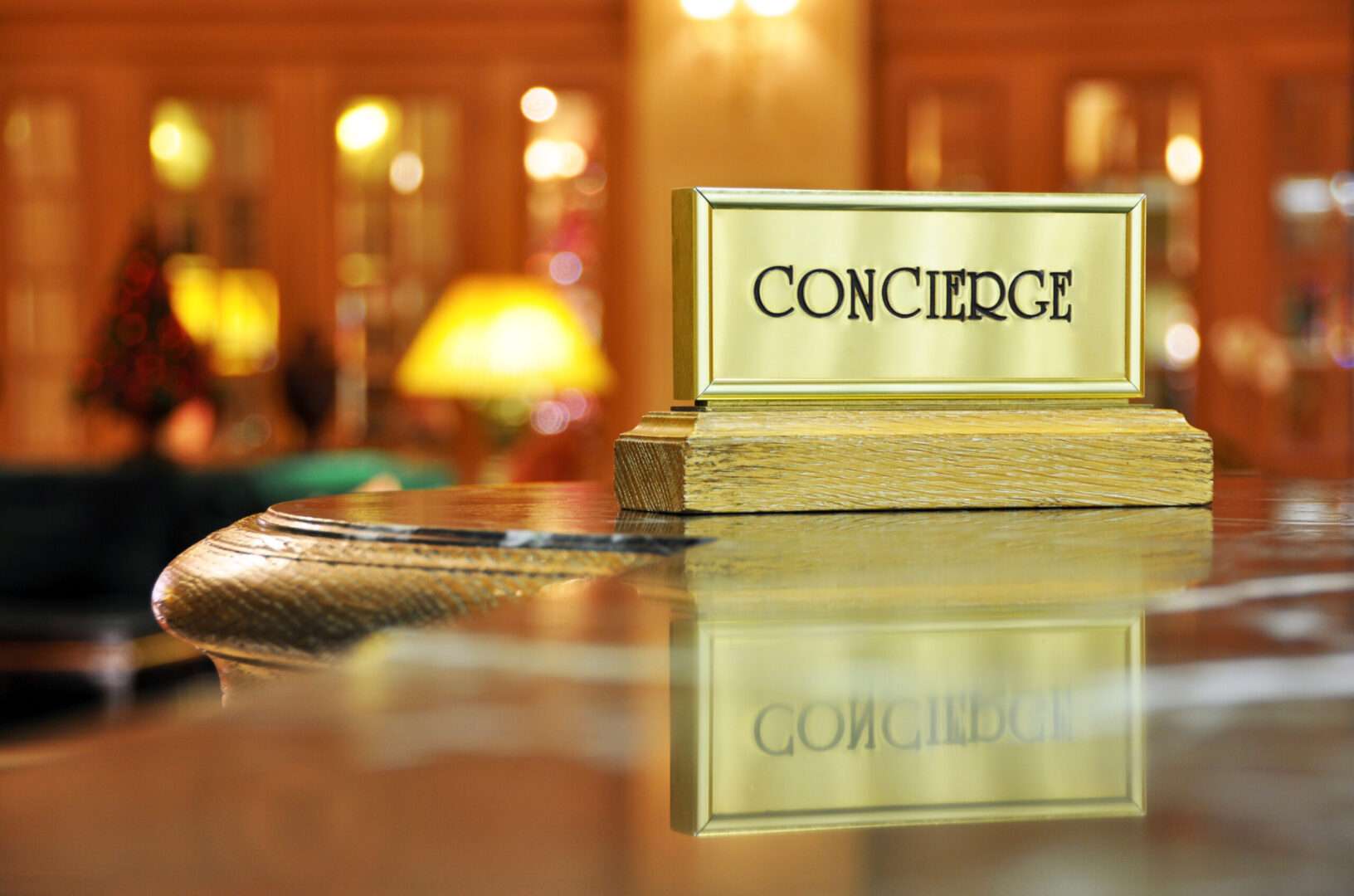 Concierge written on a gold plate with a stand on table