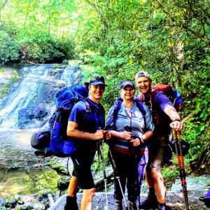 Three people backpacking at a jungle