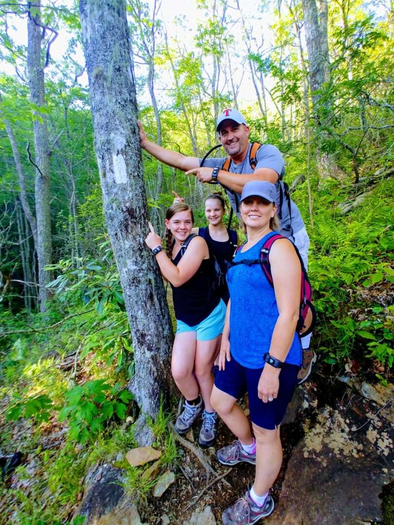 Some people standing near a tree, posing at the camera