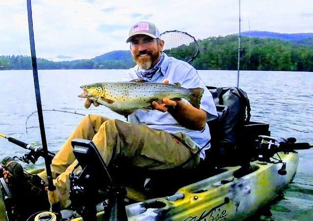 A man holding a large fish while boating