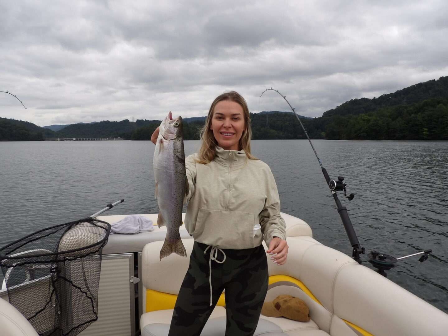 A girl standing on a boat holding a fish