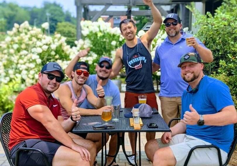 Group of men sitting on a table enjoying beer