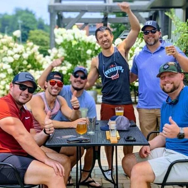Group of men sitting on a table enjoying beer