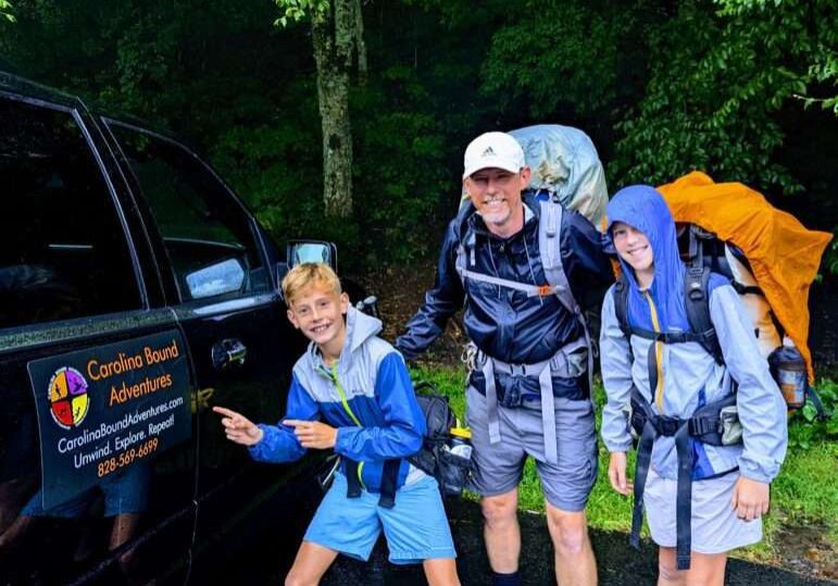 Backpackers getting a hiker shuttle ride with a Dad and Sons
