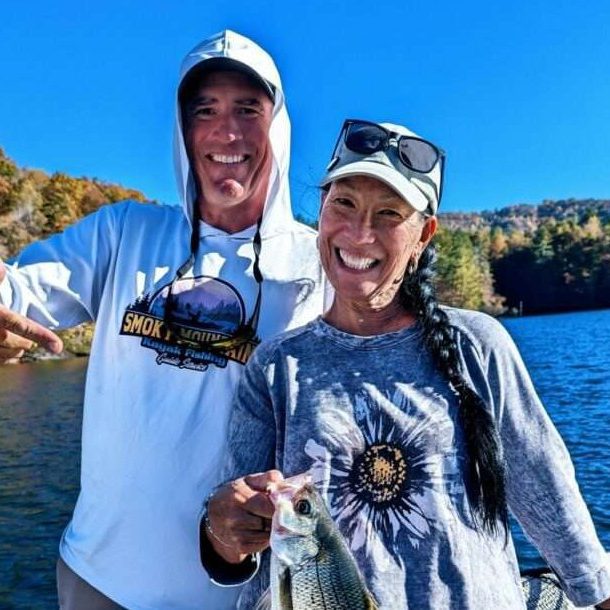 Happy lady and fishing Guide with a fish they caught on a charter boat fishing tour.