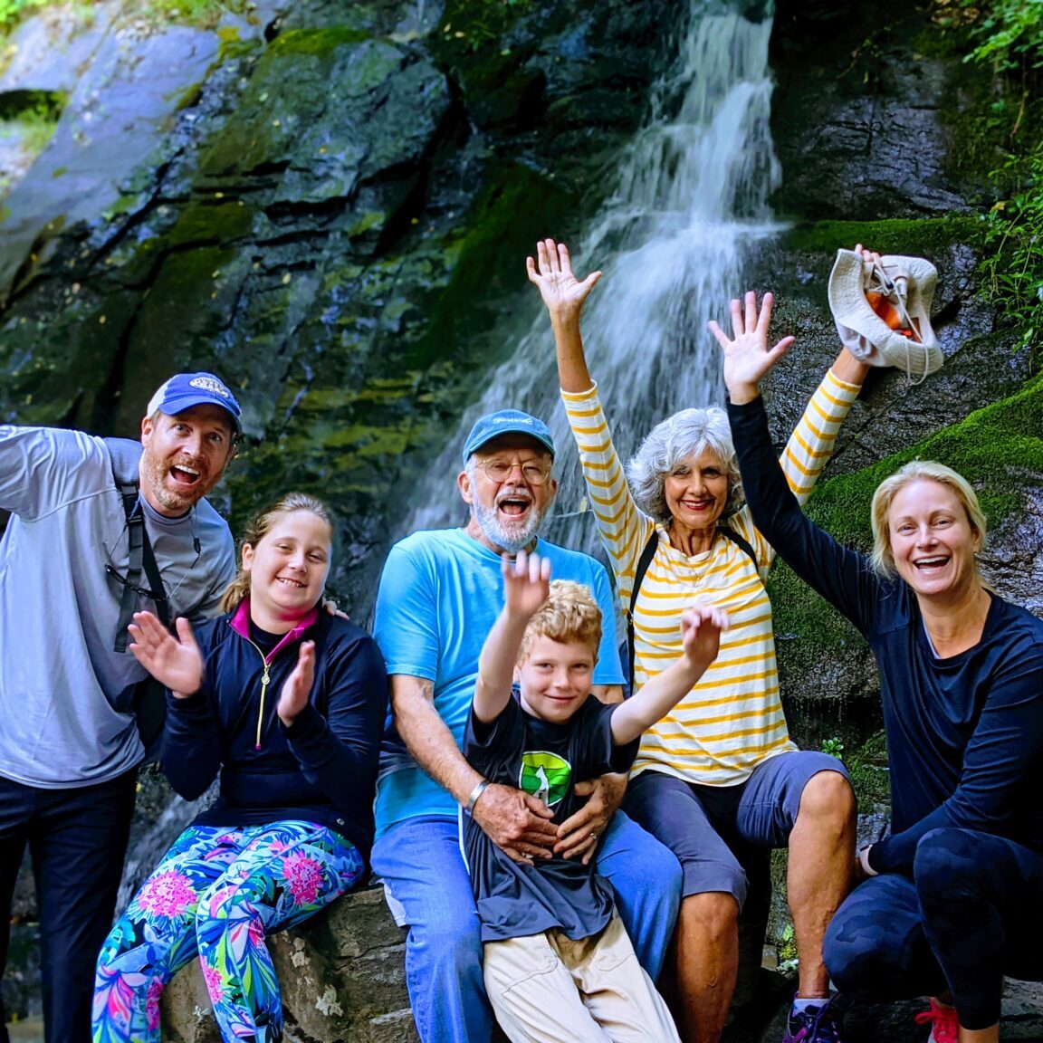 Group of people posing near waterfall